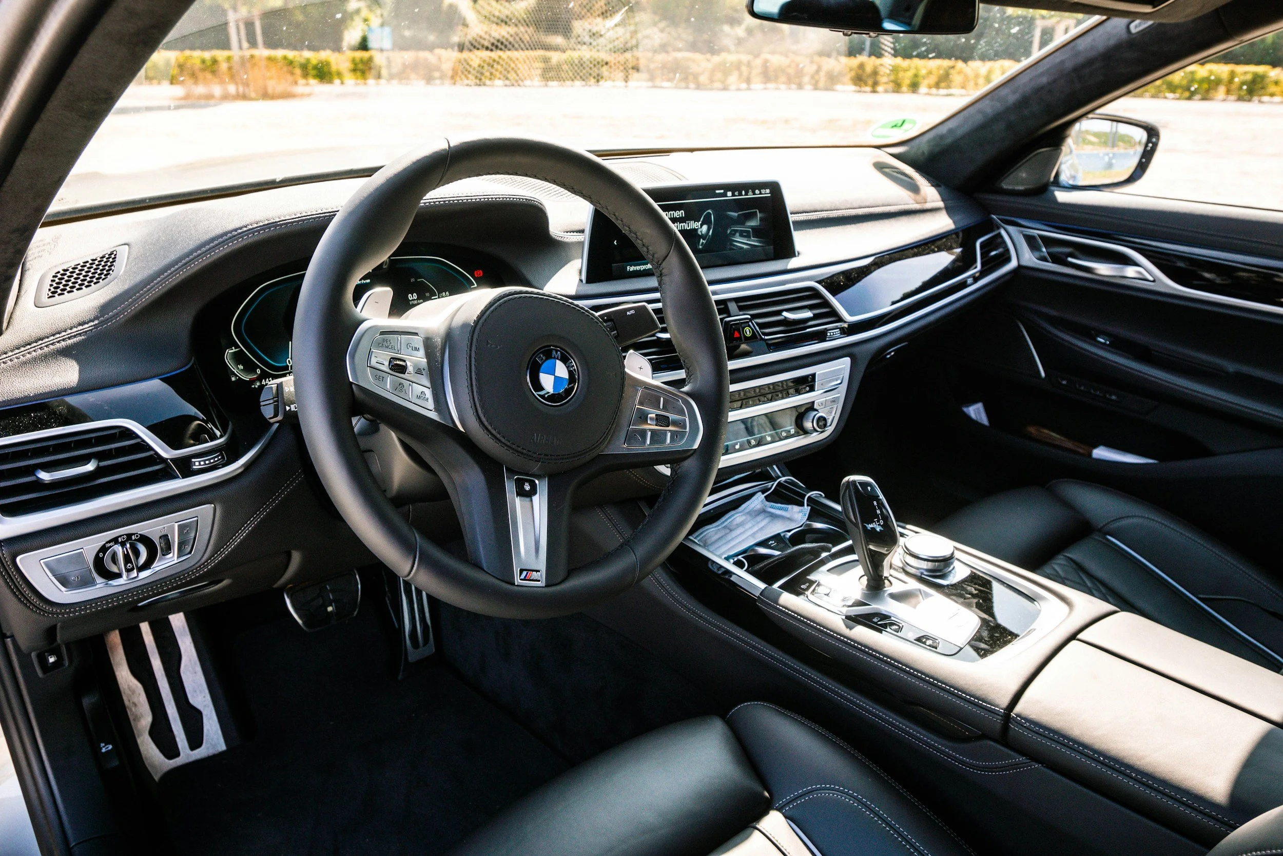Luxury BMW interior in Denver, CO, showcasing black leather steering wheel, digital infotainment system, and center console — premium interior detailing and ceramic coating services.